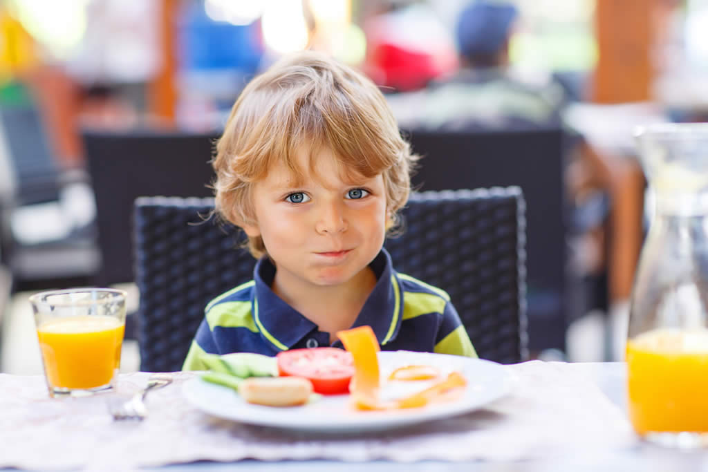 Young child enjoying a meal at a family-friendly restaurant.