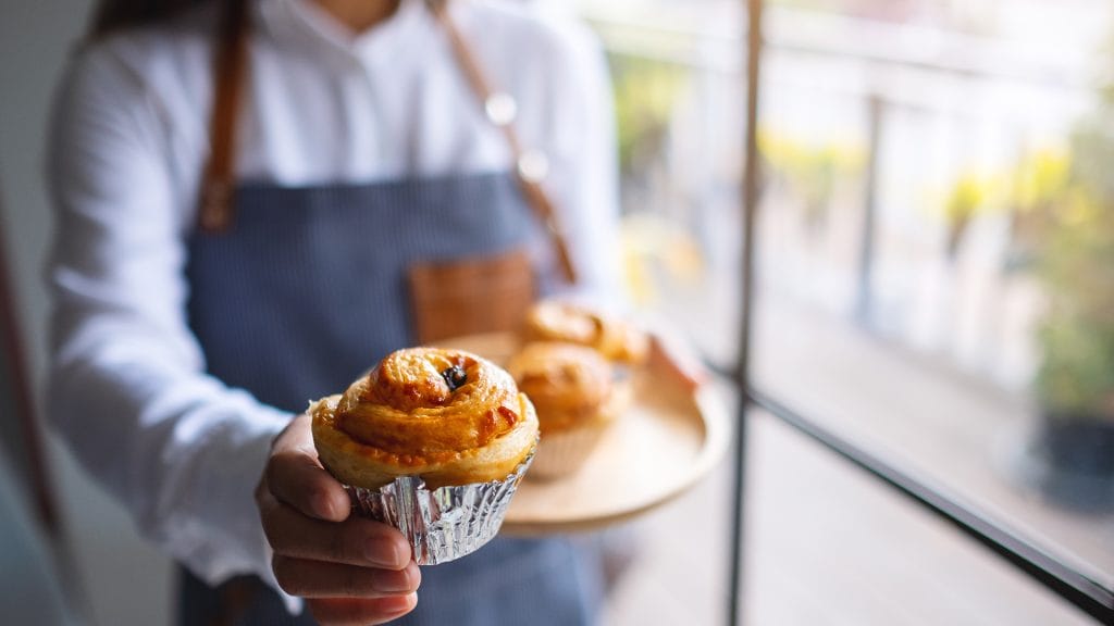 Breakfast restaurant server holding muffin